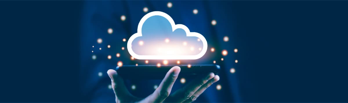 Hand holding a smartphone with a glowing cloud icon representing cloud computing and data storage