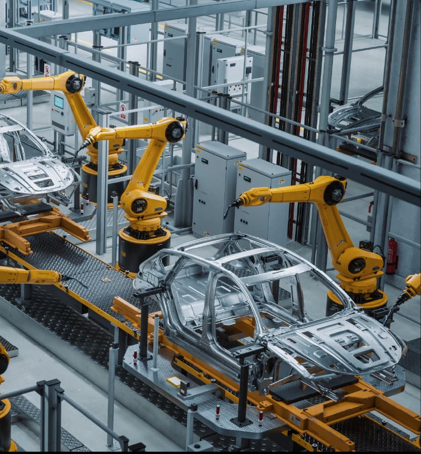 Robotic arms assembling car body frames on an automated production line inside a modern automotive facility