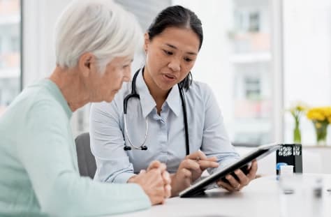 Doctor showing medical information on a digital tablet to a senior patient during a consultation Mobile