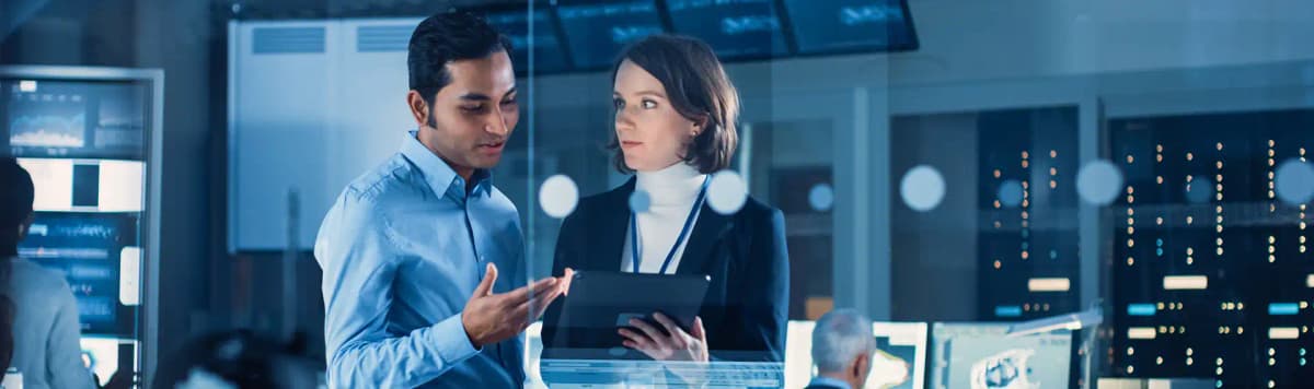 Business professionals collaborating on tablet reviewing digital data and strategies in modern corporate technology office